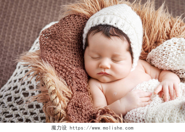 漂亮的新生婴儿的肖像美丽的小新生宝宝2周睡在一个篮子里 
